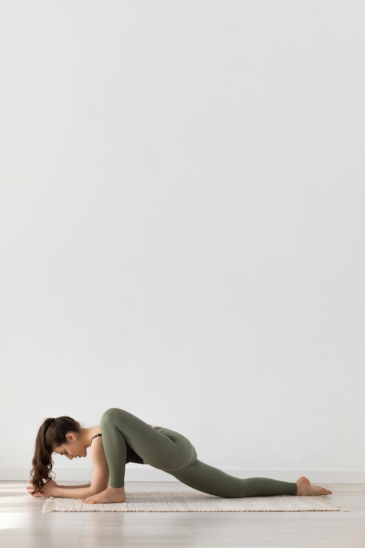 Foto ein junges mädchen macht yoga auf weißem hintergrund in einem grünen trainingsanzug