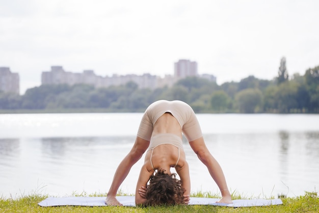 Ein junges Mädchen meditiert und macht Yoga im Stadtpark