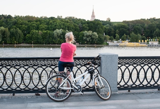 Ein junges Mädchen mit Fahrrad steht auf dem Damm in Moskau