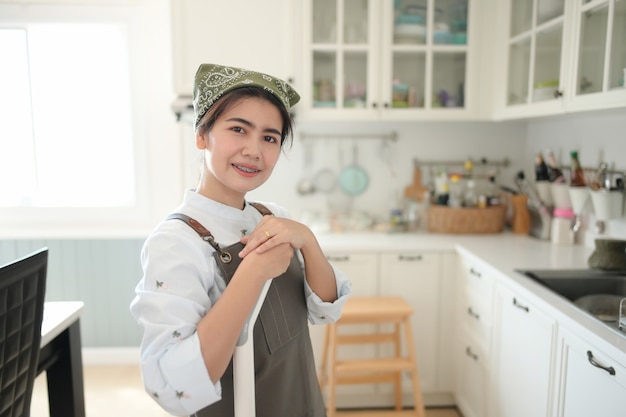 Ein junges Mädchen putzt das Haus mit einem Mopp. Es gibt eine Küchenkulisse