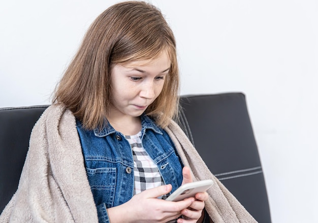 Ein junges Mädchen schaut überrascht auf den Smartphone-Bildschirm