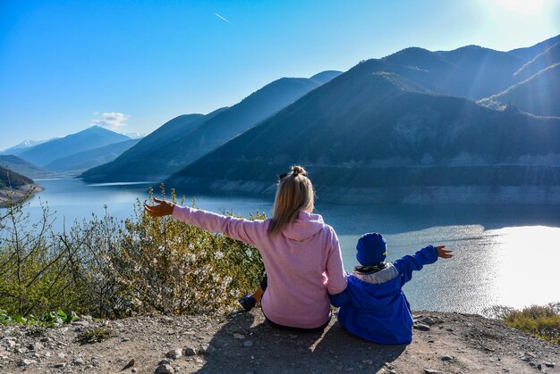 Ein junges Mädchen und ein kleiner Junge auf dem Hintergrund der Landschaft des Zhinvali-Reservoirs Georgien
