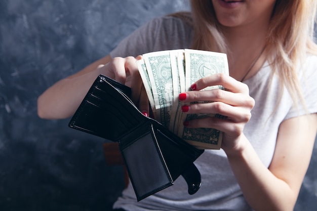 Ein junges Mädchen zieht Geldscheine aus einer Brieftasche