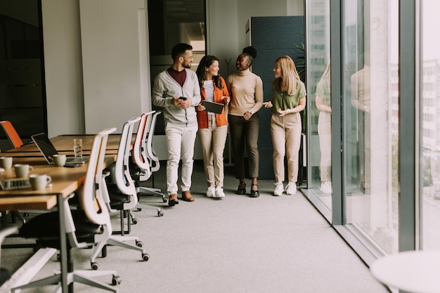 Ein junges multiethnisches Startup-Team geht durch das moderne Büro