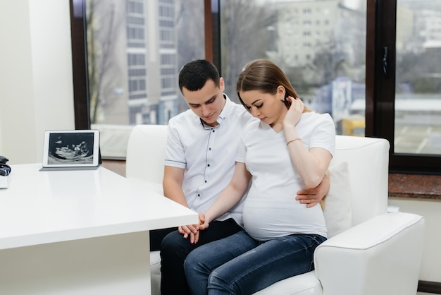 Ein junges Paar bei der Sprechstunde eines Gynäkologen nach einem Ultraschall. Schwangerschaft und Gesundheitsvorsorge.