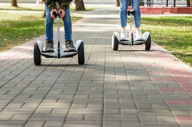 Ein junges Paar, das ein Hoverboard in einem Park reitet