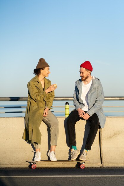 Ein junges Paar Hipster-Skateboarder entspannt sich nach dem Skateboardtraining auf einer Betonbrücke