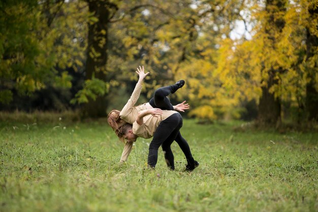 Foto ein junges paar tanzt auf einem grasbewachsenen feld im park