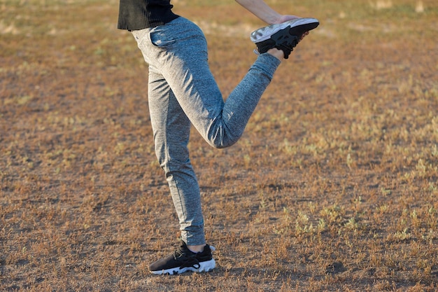 Ein junges, schlankes, athletisches Mädchen in Sportbekleidung mit Schlangenhautdrucken führt eine Reihe von Übungen aus, die sich nach der Yoga-Praxis ausruhen