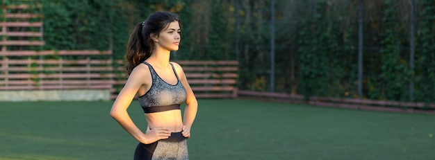 Ein junges, schlankes, athletisches Mädchen in Sportbekleidung mit Schlangenhautdrucken führt eine Reihe von Übungen aus, die sich nach der Yoga-Praxis ausruhen