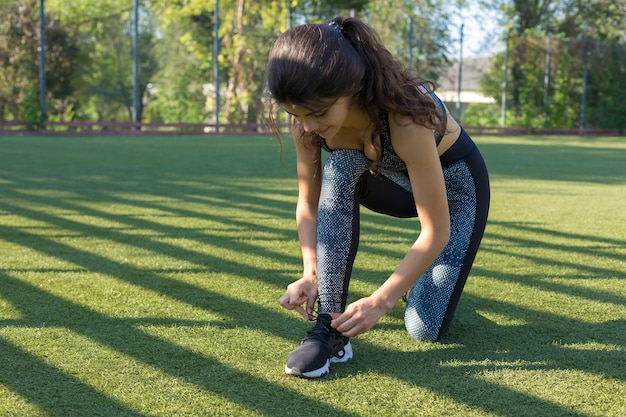 Ein junges, schlankes, athletisches Mädchen in Sportbekleidung mit Schlangenhautdrucken führt eine Reihe von Übungen durch Fitness und gesunder Lebensstil