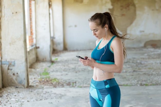 Ein junges schlankes athletisches Mädchen in Sportkleidung mit Schlangenhaut-Prints führt eine Reihe von Übungen durch