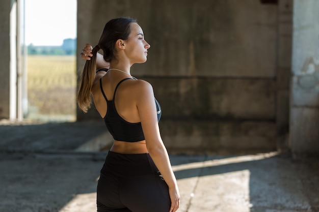 Ein junges schlankes athletisches Mädchen in Sportkleidung mit Schlangenhaut-Prints führt eine Reihe von Übungen durch