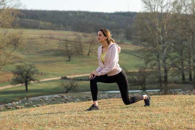 Ein junges, schlankes, sportliches Mädchen in Sportbekleidung führt eine Reihe von Übungen durch Fitness und gesunden Lebensstil