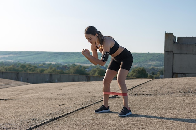 Ein junges, schlankes, sportliches Mädchen in Sportbekleidung führt eine Reihe von Übungen durch Fitness und gesunden Lebensstil