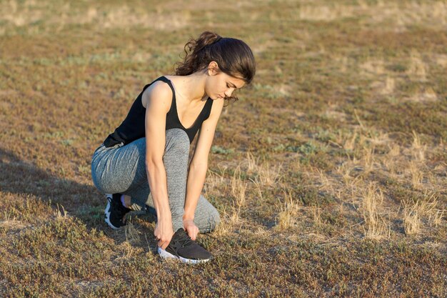 Ein junges, schlankes, sportliches Mädchen in Sportbekleidung führt eine Reihe von Übungen durch Fitness und gesunden Lebensstil