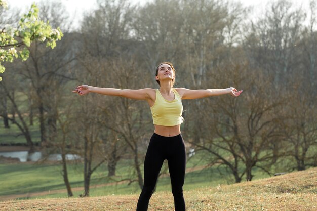 Ein junges, schlankes, sportliches Mädchen in Sportbekleidung führt eine Reihe von Übungen durch Fitness und gesunden Lebensstil