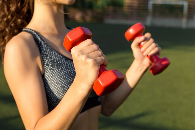 Ein junges, schlankes, sportliches Mädchen in Sportkleidung mit Schlangenhaut-Prints führt eine Reihe von Übungen durch. Fitness und gesunder Lebensstil.