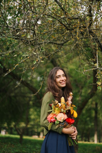 Ein junges schönes Brunettemädchen mit Blumen in ihren Händen