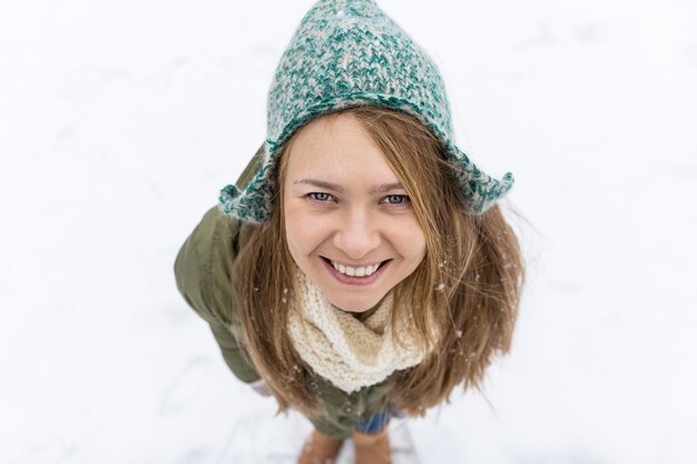 Ein junges schönes Mädchen mit langen blonden Haaren genießt den ersten Schnee