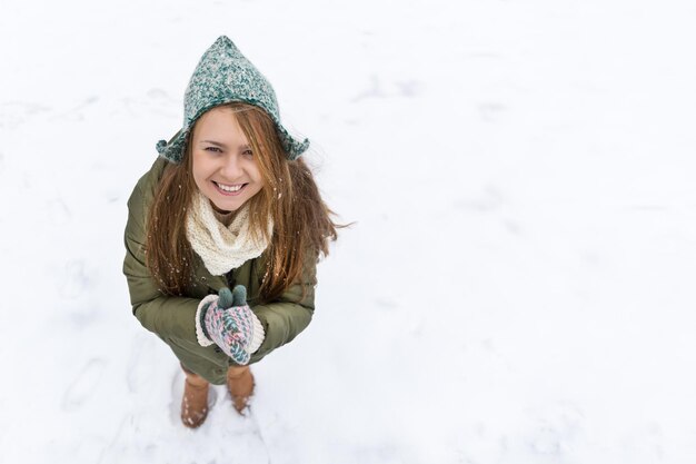 Ein junges schönes Mädchen mit langen blonden Haaren genießt den ersten Schnee