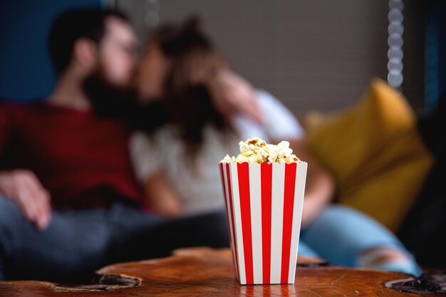 Ein junges verliebtes Paar, das nachts fernsieht, romantische Date-Nacht, die auf der Couch liegt und Popcorn isst, glückliches Dating