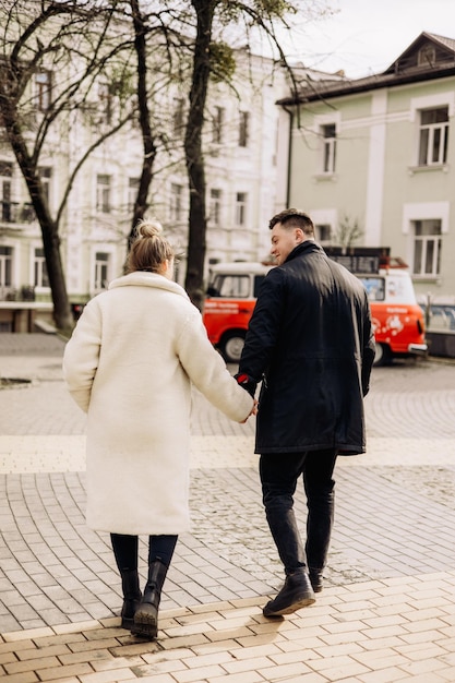 Ein junges verliebtes Paar geht auf die Straße und genießt die frische Luft Glückliches Ehepaar Ein stilvolles Paar, ein Mann und eine Frau