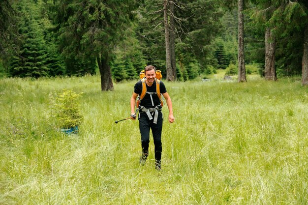 Ein kaukasischer Wanderer mit einem aktiven Lebensstil erkundet einen hochgelegenen Waldweg mit einem