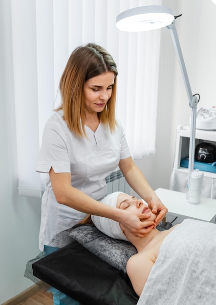 Ein kaukasisches Mädchen schläft während einer Gesichtsmassage im Spa-Kosmetik-Bereich