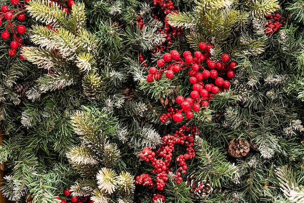 Ein Kegel und ein roter Ebereschenbaum auf einem Fichtenzweig, Nahaufnahmedekorationen für das neue Jahr und ein Weihnachtstannenzapfen auf einem Weihnachtsbaum