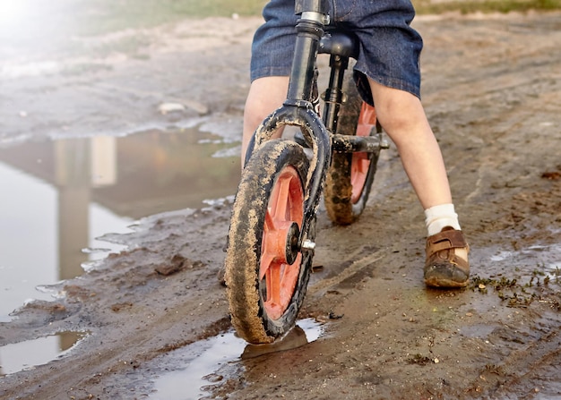 Ein Kind auf einem Fahrrad fährt durch den Schlamm