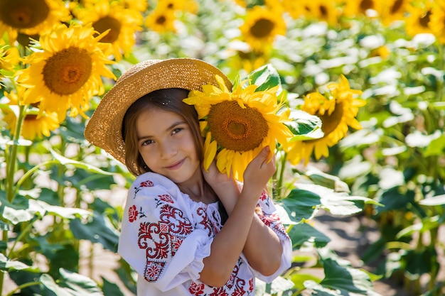 Ein Kind in einem Sonnenblumenfeld in einem bestickten Hemd. Ukraine-Unabhängigkeitstag-Konzept. Selektiver Fokus.