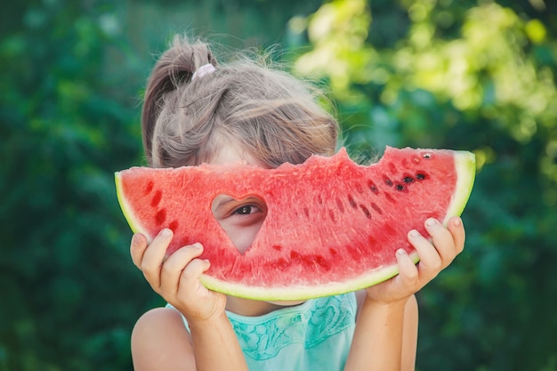 Ein Kind isst Wassermelone.