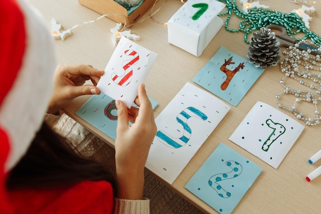 Ein Kind macht aus Papier einen Weihnachts-Adventskalender mit seinen eigenen Händen diy Nahaufnahme