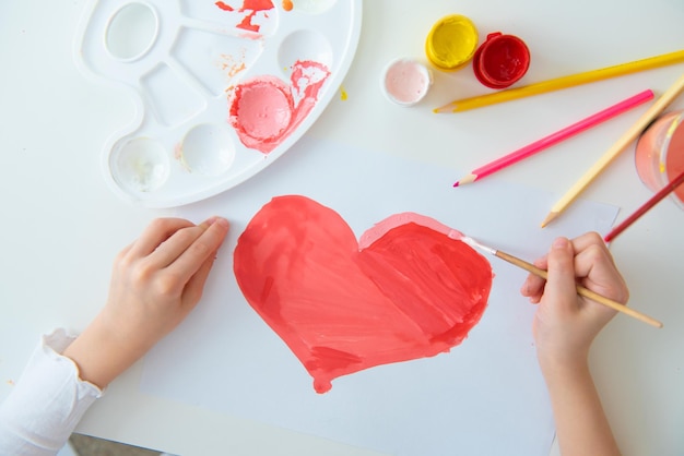 ein kind malt seiner mutter zum valentinstag ein herz