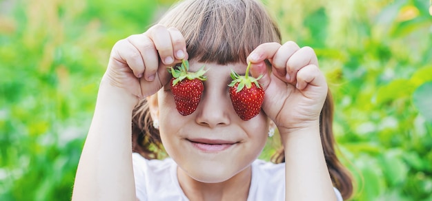 Ein Kind mit Erdbeeren in den Händen