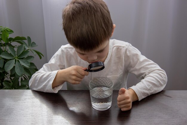 Ein Kind schaut durch eine Vergrößerung auf das Wasser.