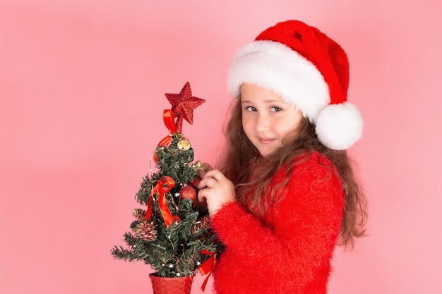 Ein Kind schmückt den Weihnachtsbaum mit Weihnachtsspielzeug