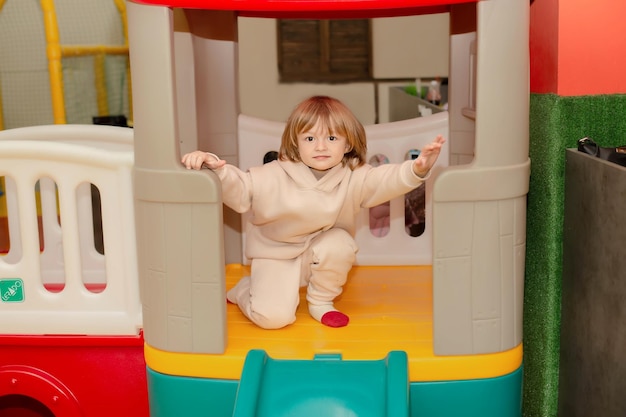 Ein Kind spielt in einem Spielhaus mit einer Rutsche, auf der „das Wort“ steht.