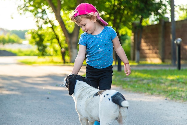 Ein Kind spielt mit einem kleinen Hund im Park. Selektiver Fokus