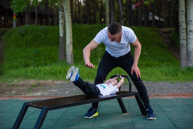 Ein Kind spielt mit einem Mann auf einem Spielplatz