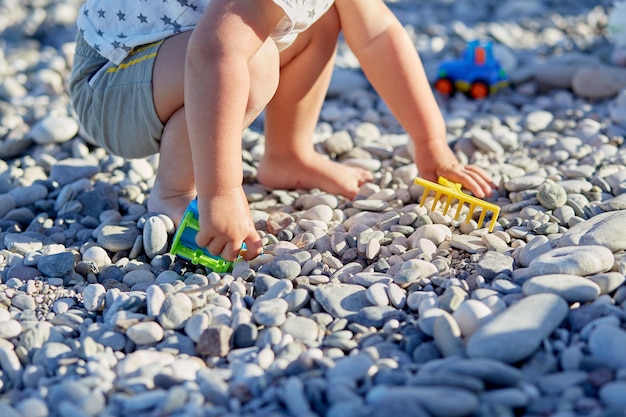 Ein Kind spielt mit Spielzeug und Kieselsteinen am Strand Das Konzept des Erholungsspiels und die Entwicklung der motorischen Fähigkeiten von Kindern39 Hochwertiges Foto