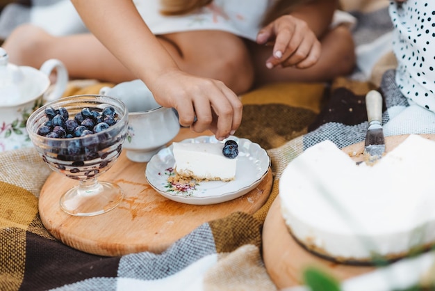 Ein Kind verziert einen Kuchen mit Heidelbeeren