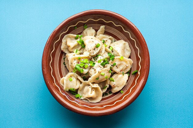 ein klassisches traditionelles Gericht aus Pelmeni-Knödeln mit Fleisch, Butter, Pfeffer und Gemüse, Essen