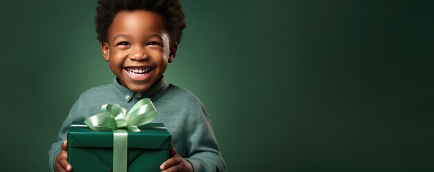 Ein kleiner afrikanischer Junge öffnet ein Geschenk und lacht auf grünem Hintergrund Banner Kopierraum Generative ai