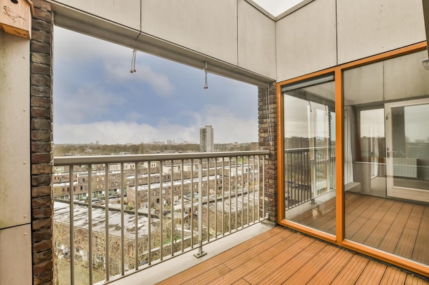 Ein kleiner Balkon mit Metallzaun und Holzboden in einem modernen Haus