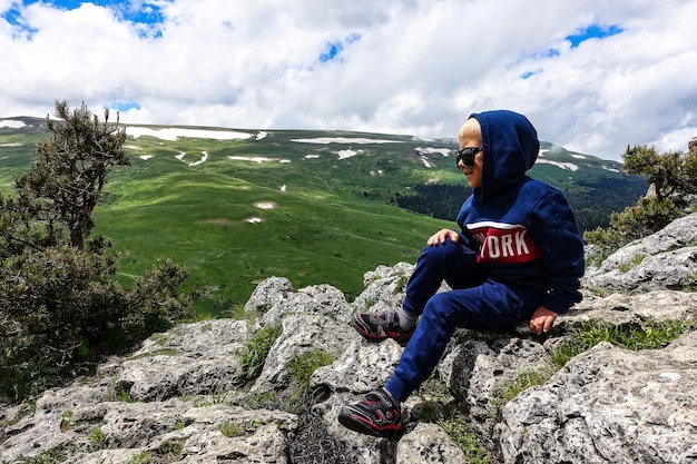 Ein kleiner Junge auf dem Hintergrund der alpinen Wiesen des LagoNaki-Plateaus in Adygea Russland 2021