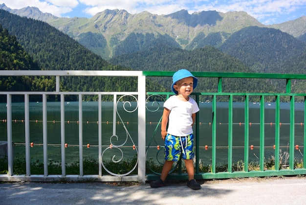 Foto ein kleiner junge auf dem hintergrund eines wunderschönen bergsees ritsa abchasien 2017