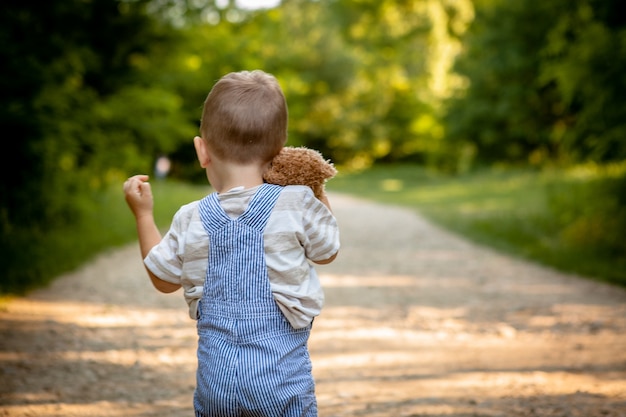 Ein kleiner Junge auf einer Straße im Wald