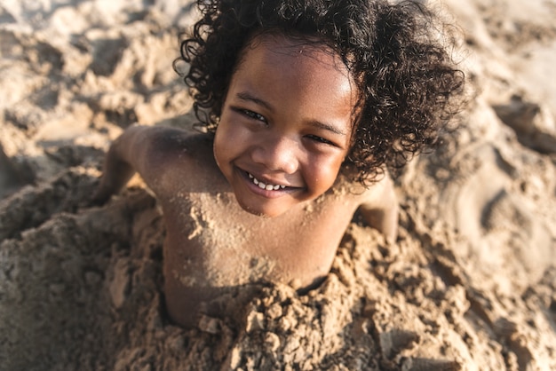Ein kleiner Junge, der im Sand spielt